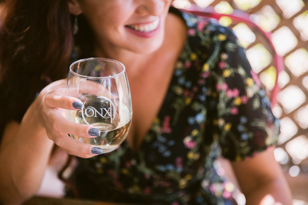 Image of woman holding stemless glass