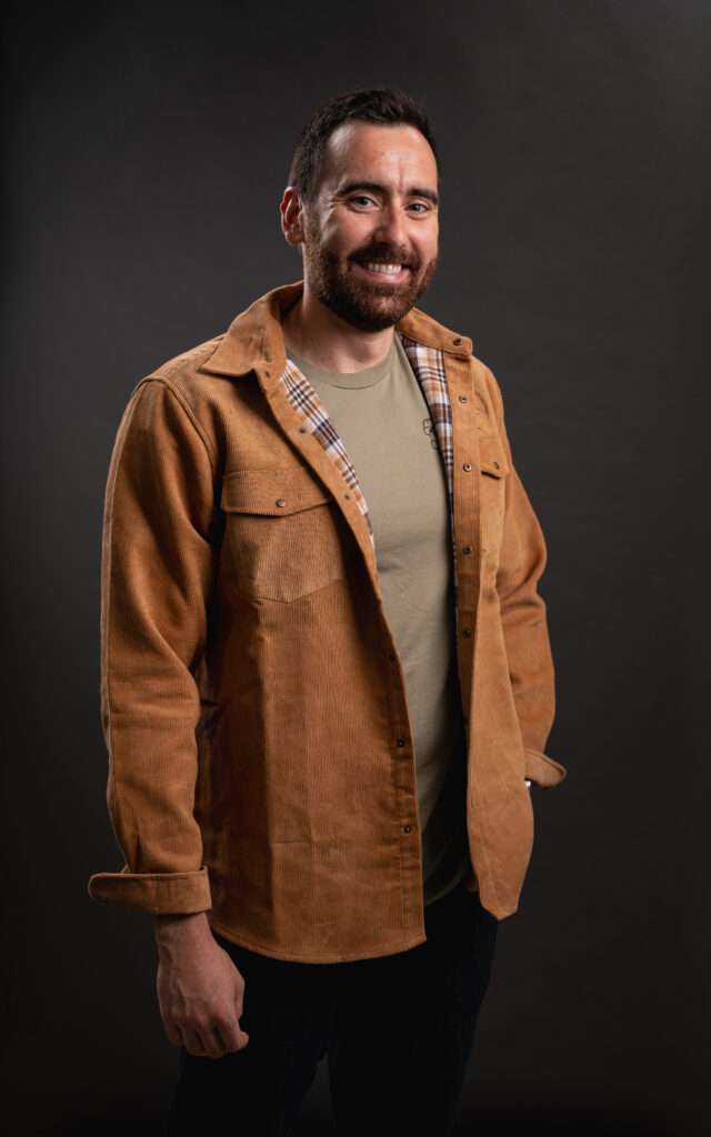Image of http://Bearded%20man%20smiling%20and%20wearing%20a%20tan%20corduroy%20shacket%20with%20ONX%20logo